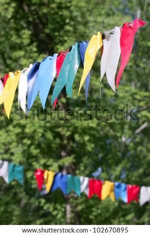 colorful bunting flags against green forest