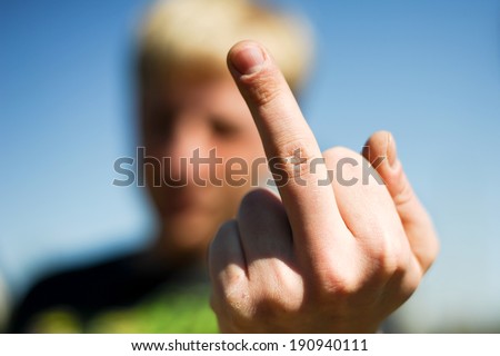 Young guy showing middle finger gesture.