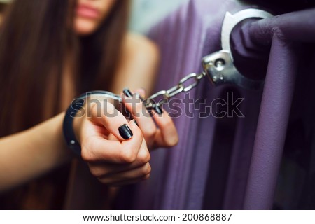 Young women locked with handcuffs to radiator