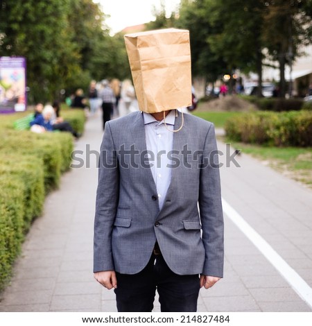 Businessman with paper bag on the head in the street