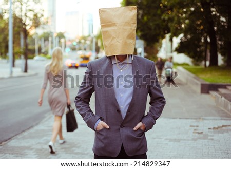Man with paper bag on the head in the street