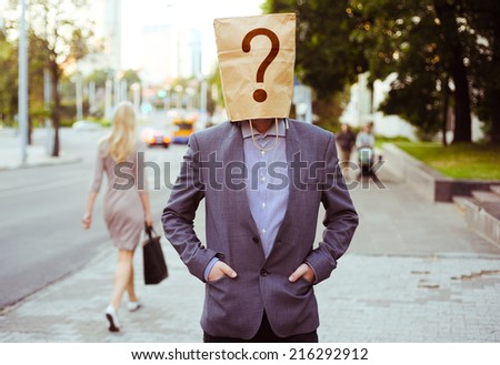 Man with a paper bag on head in the street