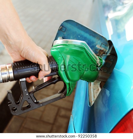 Woman hand refilling the car with fuel on a filling station.