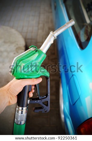 Woman hand refilling the car with fuel on a filling station.