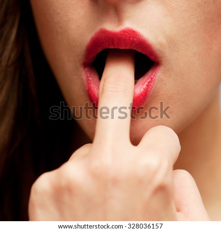 Young beautiful girl putting the middle finger in her mouth
