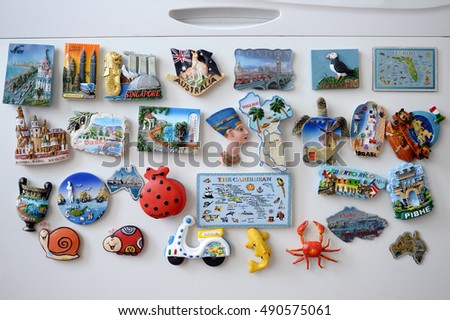 many different travel magnet souvenires on the fridge