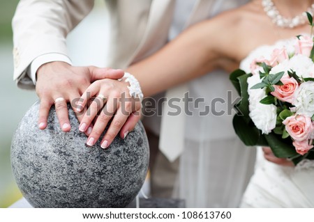 Bride and groom with flowers and wedding rings