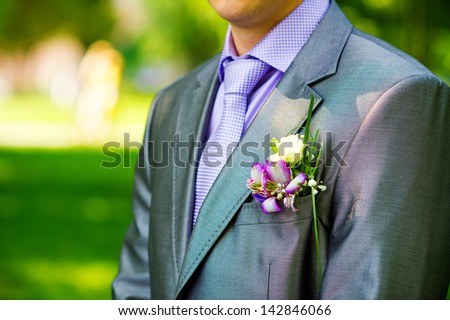 Closeup groom\'s buttonhole with delicate purple flowers