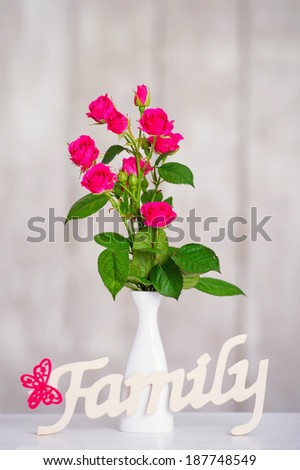 Still life with delicate roses and interior decoration wooden family word