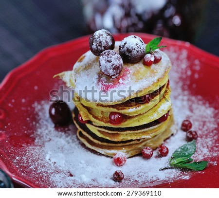Stack of delicious pancakes with berries, mint and sugar powder