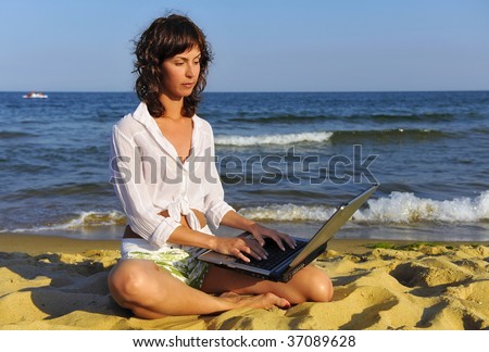 Woman working on a laptop at the seaside