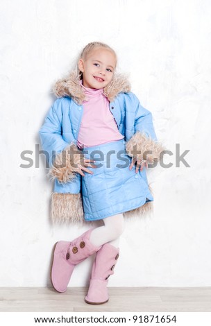 Little cute girl posing in fashion blue winter outfit