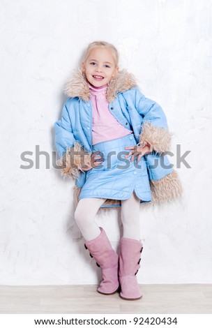 Cute blonde girl posing in fashion winter outfit