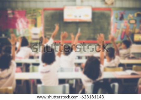 Blurred Student hands up asking a question in class at the elementary school. Education concept.