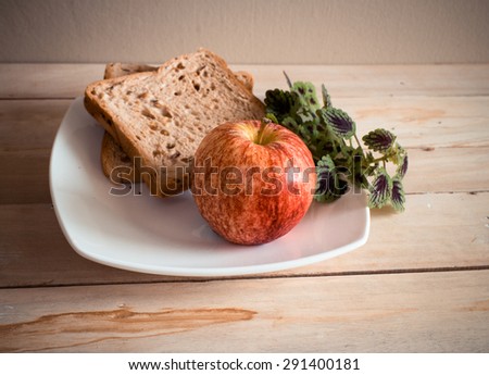 apple with whole wheat bread on white plate