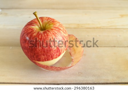 still life with apple  peeled skin on wooden table