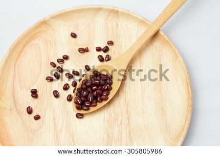 Red Bean (selective focus) in wood spoon on wood plate isolate white background.