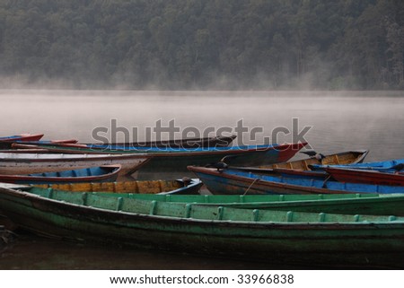 Boats in the morning fog on Lake Phewa in Pokhara, Nepal