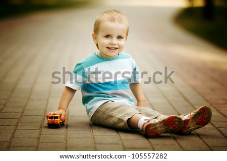 little boy plays with toy car