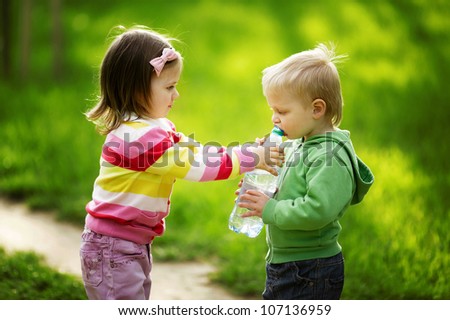 boy and girl sharing bottle of water
