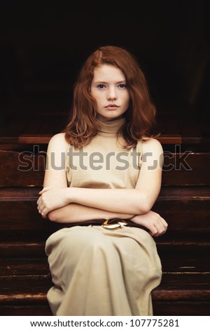 beautiful red-haired woman resting on the streets of the beautiful city