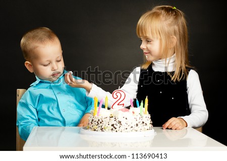 funny girl feeds boy with birthday cake