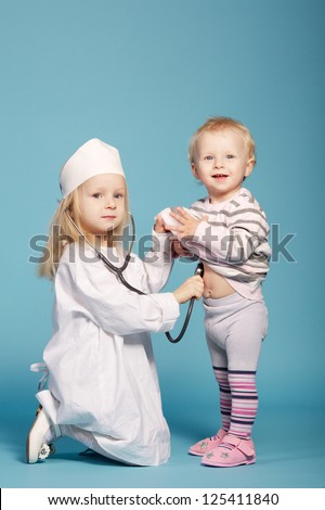 two cute little girls playing doctor. studio photo