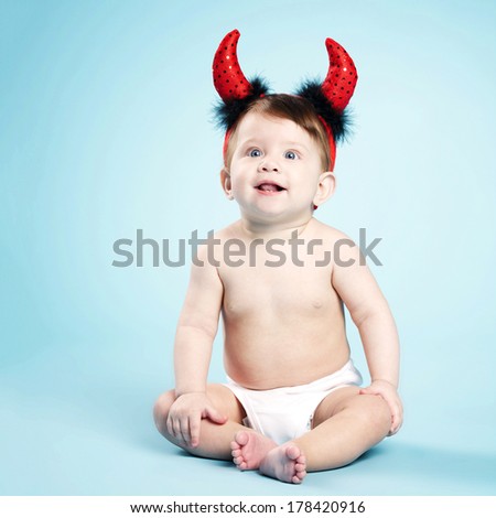 little funny baby with devil horns on blue background