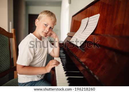 little boy plays piano at home