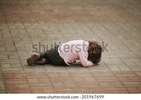 alone crying girl lying on asphalt