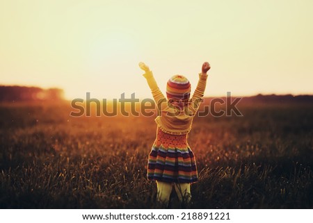 little cute girl runnig to the sunset