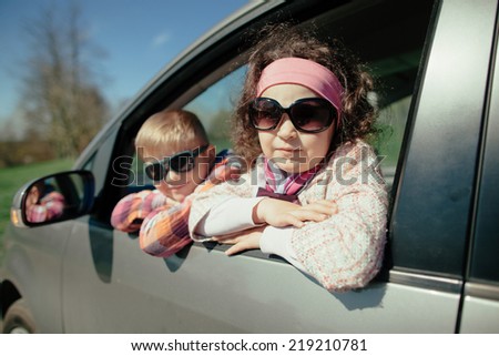 little pretty girl and cute boy driving fathers car