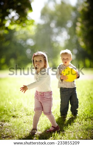 boy and girl playing with yellow ball