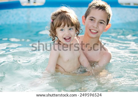 brother and sister bathe outside in the pool