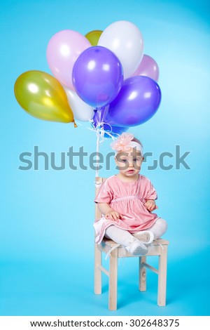 cute little girl with balloons on blue background