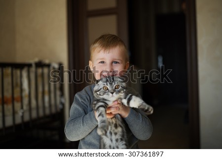 photo of little funny boy hugs cat