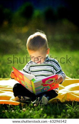 little boy reads a book