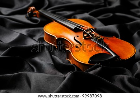 aged violin on dark fabric texture