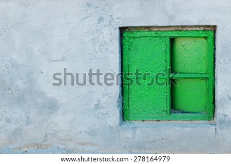 The old gray wall with green window right