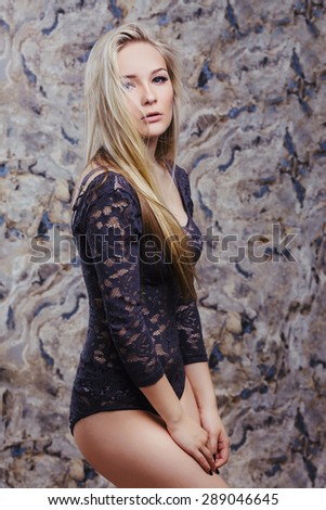 Portrait of attractive caucasian young woman blonde. Perfect slim body. Studio shot. Long hair head and shoulders. Looking at camera. Passionate look.