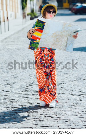 Full length travel tourist woman looking at the map in Europe. Vintage retro style white girl on vacation. Traveling outdoors.