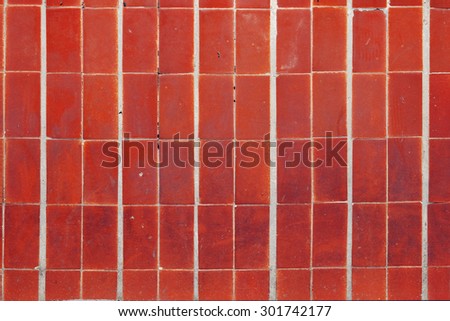 Dirty red tiles, stained and cracked, and the white spaces between it, background texture