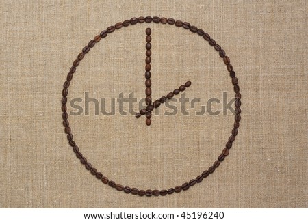 Clock made of fried coffee beans on grunge canvas. Coffee time concept.