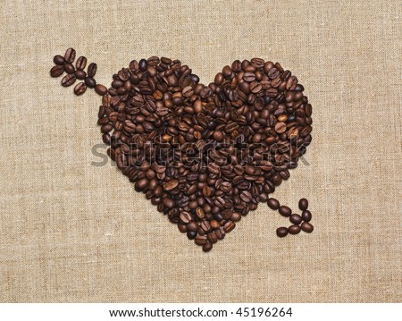 Love, coffee lover, made with love concepts. Heart with Cupid arrow made of fried coffee beans on grunge canvas.