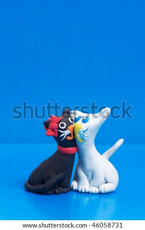 Two sweet plasticine black and white cats in love with copyspace