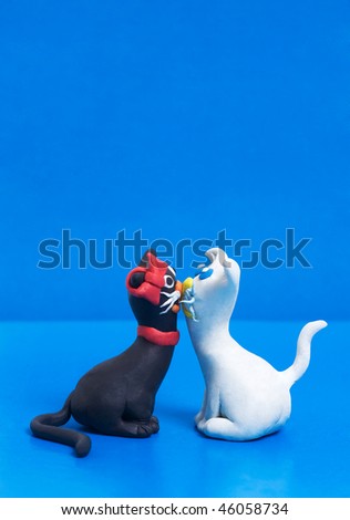 Two sweet plasticine black and white cats in love with copyspace