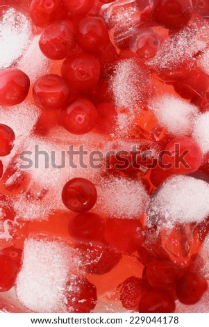 Cocktail with cranberry juice and ice cubes close up top view