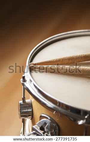 Worn drumsticks on top of a snare drum.