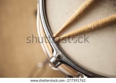 Worn drum sticks on top of a snare drum.