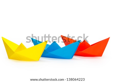 Tree colored paper ships on a white background